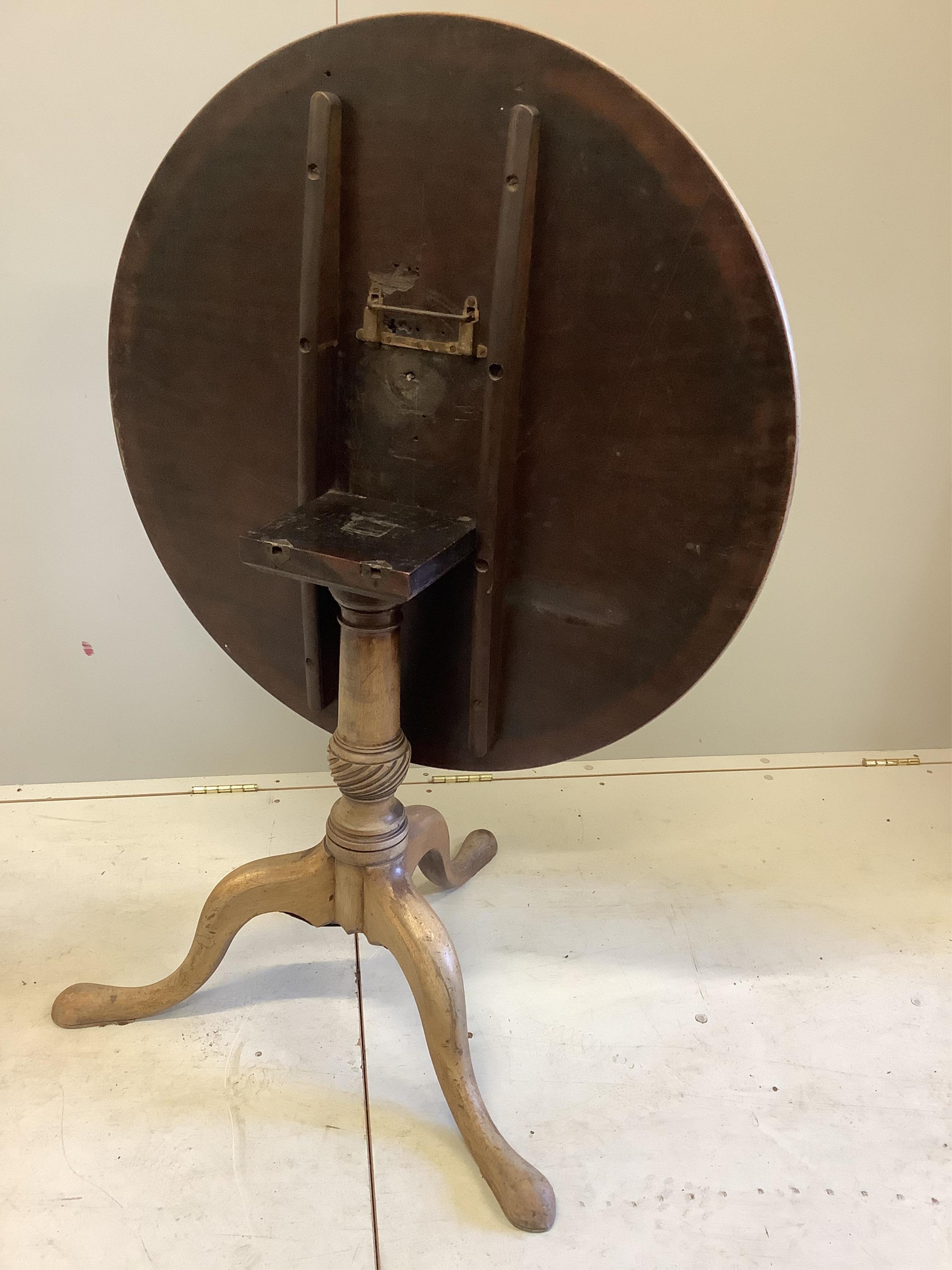 A George III circular faded mahogany tilt top tripod tea table, diameter 85cm, height 70cm. Condition - poor